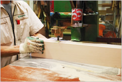 Factory worker cutting the wood with the machine